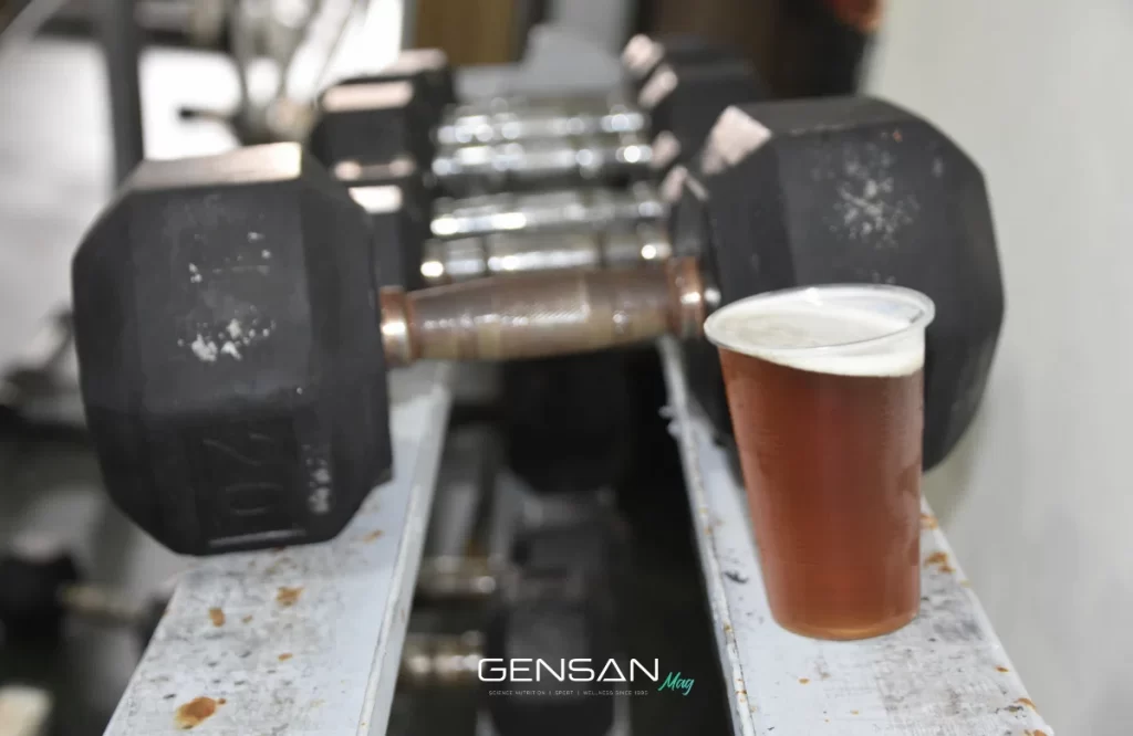 bicchiere di birra di plastica appoggiato accanto ad alcuni manubri da palestra
