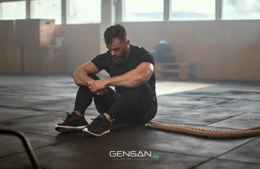atleta seduto per terra in palestra a causa della stanchezza primaverile