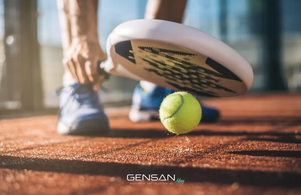 atleta durante una partita di padel fa rimbalzare a terra la pallina con la racchetta