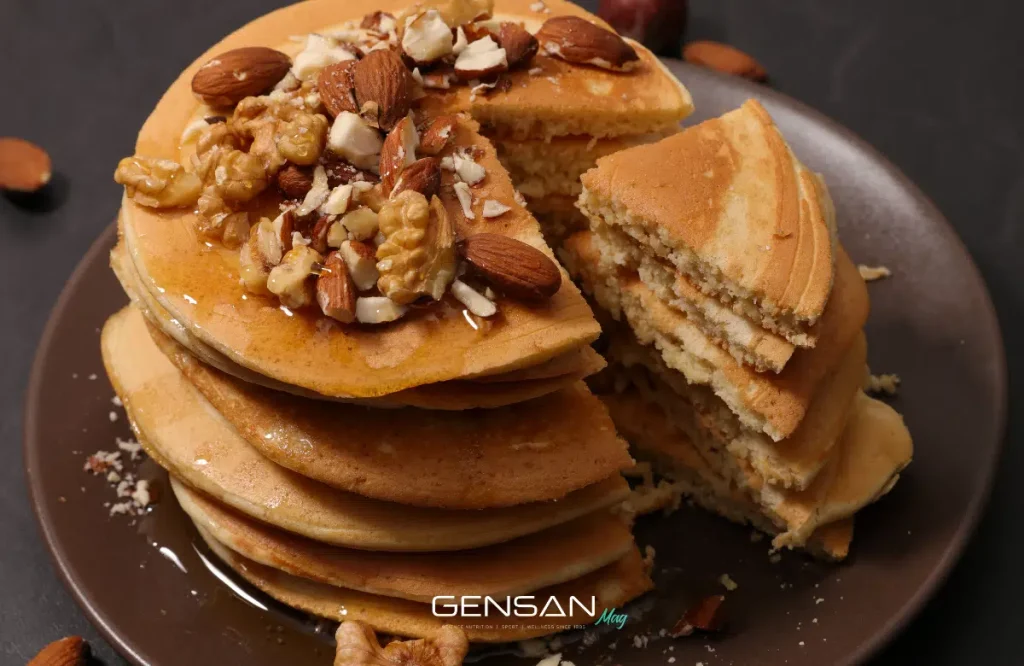 pancake proteici impilati e tagliati a fette con frutta secca